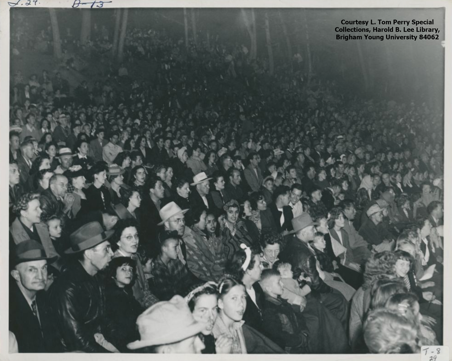 A large crowd of people are in the Theater of the Pines amphitheater in this black and white photo