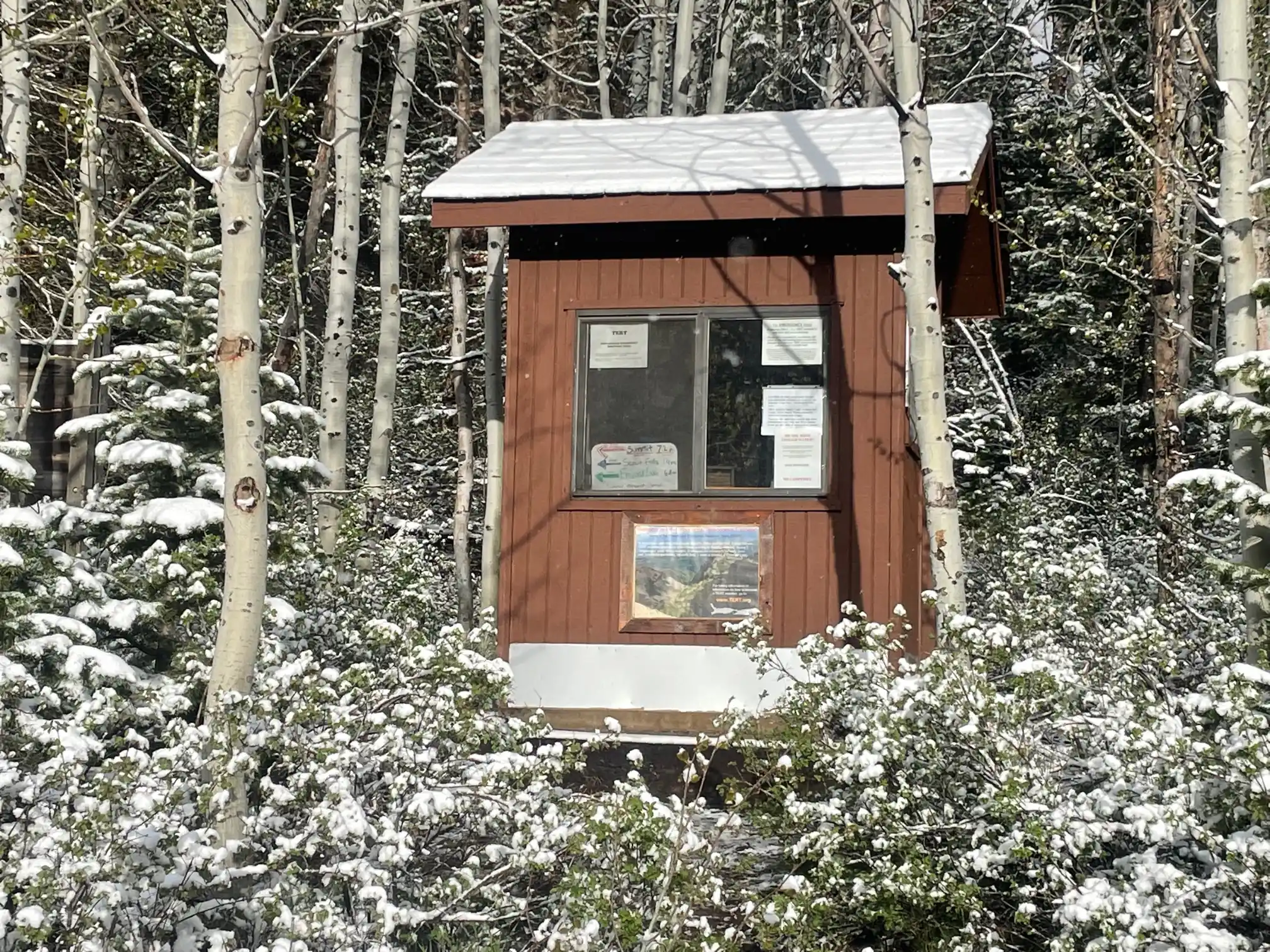 The brown TERT shack is shown in the forest with a light dusting of snow