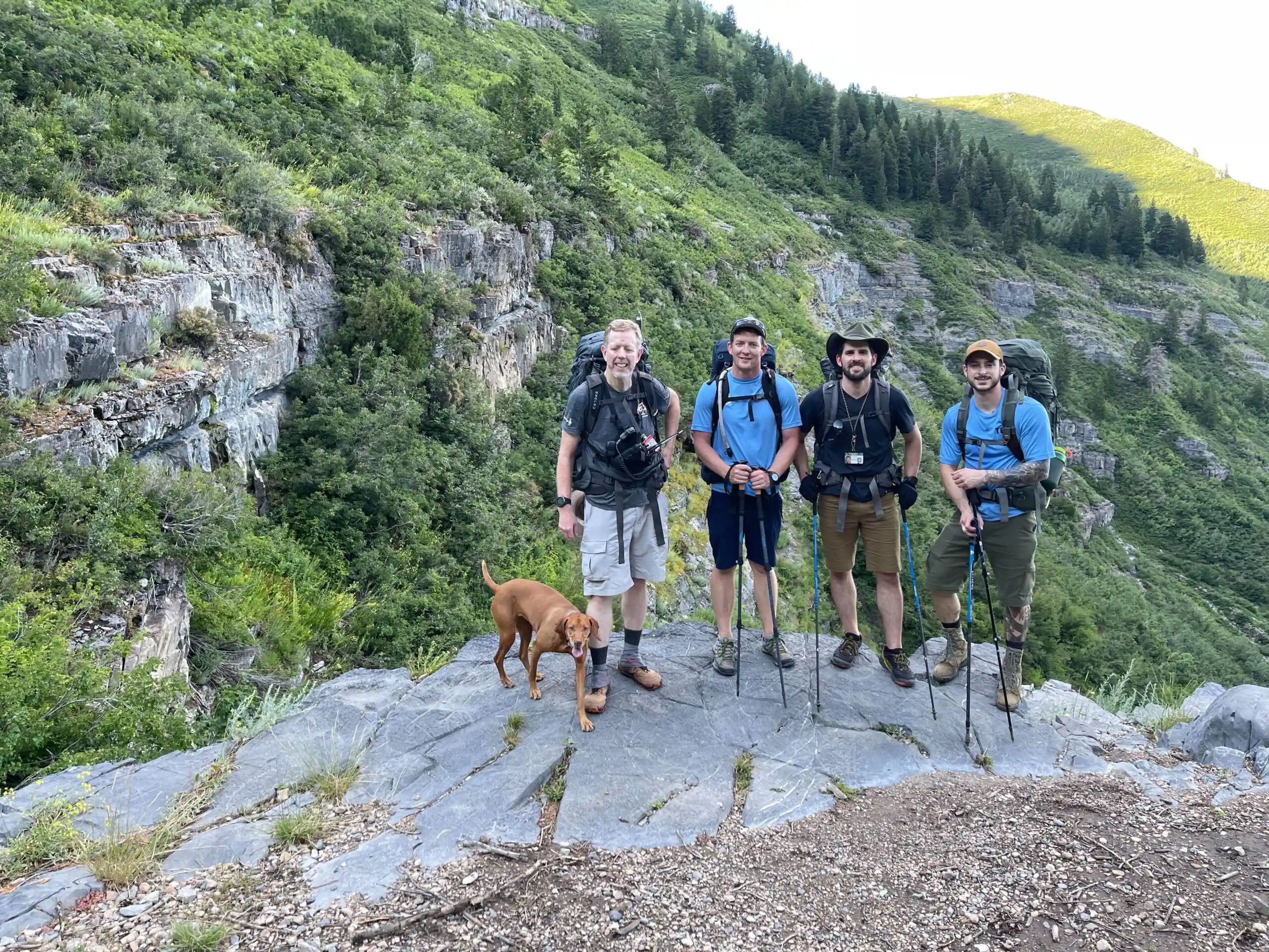 Four hikers and a dog pose for a picture