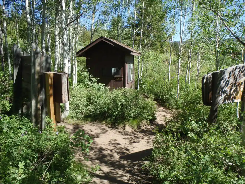 The brown TERT shack is shown in the forest.